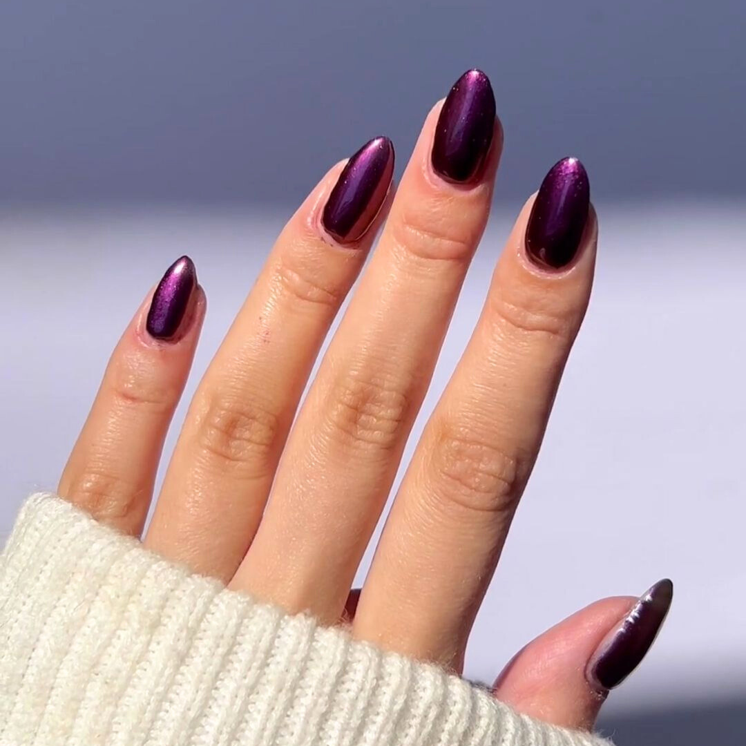 Nails showing dark purple shade with metallic effect